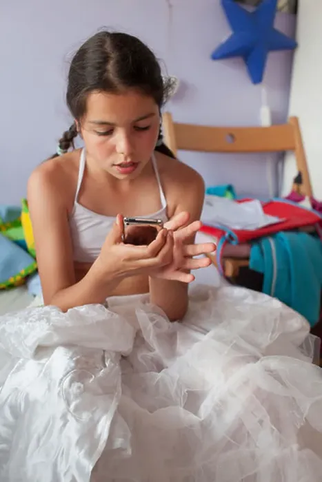 Framed Print : Adolescent girl checks social network site on mobile device Framed Print : Adolescent girl checks social network site on mobile device