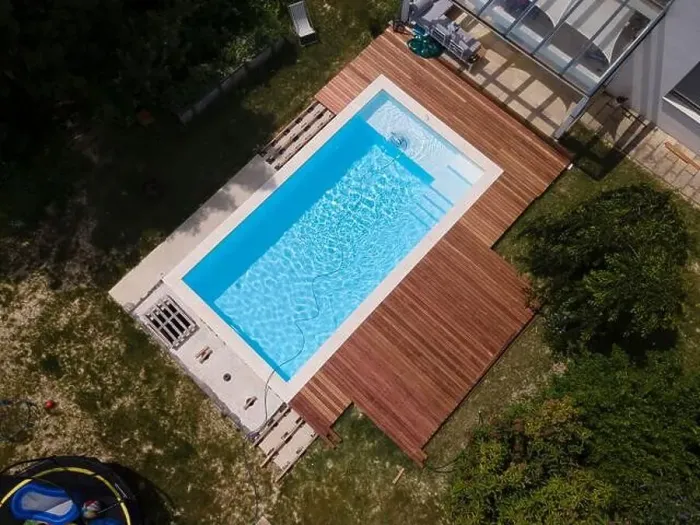 Framed Print : aerial drone flight over beautiful green garden with pool and the wooden deck of the pool is in progress
