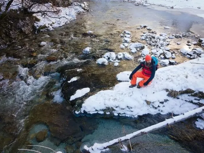 Framed Print : Aerial drone shot of hiker with backpack, orange cap and orange pants next to cold mountain stream in canyon Framed Print : Aerial drone shot of hiker with backpack, orange cap and orange pants next to cold mountain stream in canyon