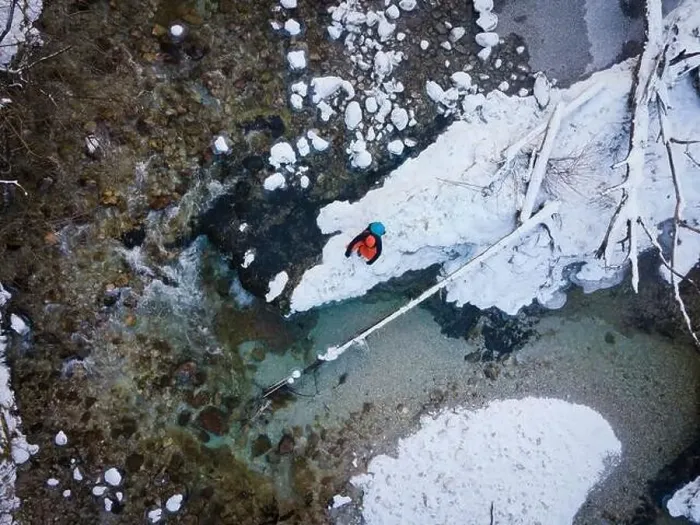 Framed Print : Aerial drone shot of hiker with backpack, orange cap and orange pants next to cold mountain stream in canyon Framed Print : Aerial drone shot of hiker with backpack, orange cap and orange pants next to cold mountain stream in canyon