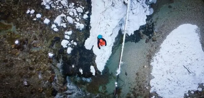 Framed Print : Aerial drone shot of hiker with backpack, orange cap and orange pants next to cold mountain stream in canyon Framed Print : Aerial drone shot of hiker with backpack, orange cap and orange pants next to cold mountain stream in canyon