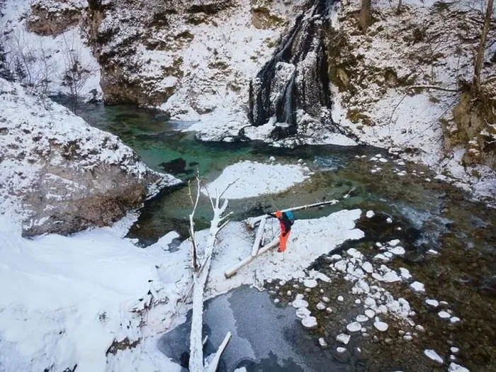 Framed Print : Aerial drone shot of hiker with backpack, orange cap and orange pants next to cold mountain stream in canyon Framed Print : Aerial drone shot of hiker with backpack, orange cap and orange pants next to cold mountain stream in canyon