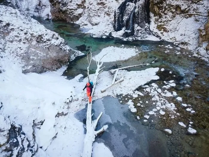 Framed Print : Aerial drone shot of hiker with backpack, orange cap and orange pants next to cold mountain stream in canyon Framed Print : Aerial drone shot of hiker with backpack, orange cap and orange pants next to cold mountain stream in canyon