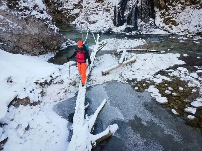 Framed Print : Aerial drone shot of hiker with backpack, orange cap and orange pants next to cold mountain stream in canyon Framed Print : Aerial drone shot of hiker with backpack, orange cap and orange pants next to cold mountain stream in canyon