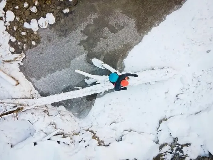 Framed Print : Aerial drone shot of hiker with backpack, orange cap and orange pants next to cold mountain stream in canyon Framed Print : Aerial drone shot of hiker with backpack, orange cap and orange pants next to cold mountain stream in canyon