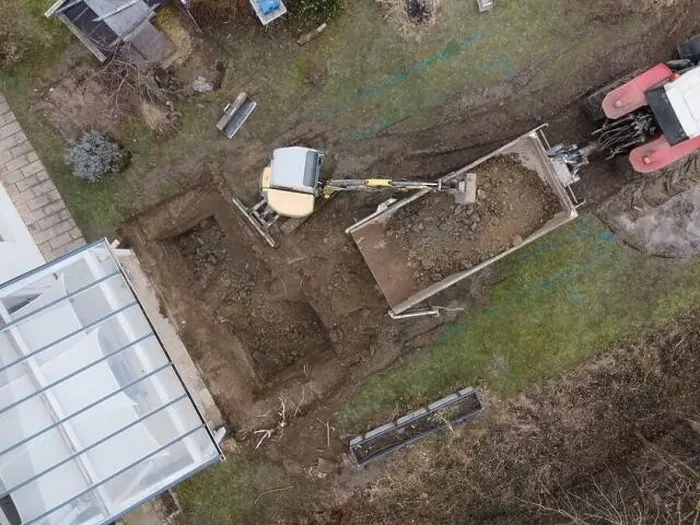 Framed Print : aerial drone shot of small, yellow excavator stands in a large garden and digs a hole for a pool in austria Framed Print : aerial drone shot of small, yellow excavator stands in a large garden and digs a hole for a pool in austria
