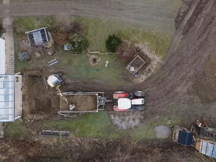 Framed Print : aerial drone shot of small, yellow excavator stands in a large garden and digs a hole for a pool in austria Framed Print : aerial drone shot of small, yellow excavator stands in a large garden and digs a hole for a pool in austria