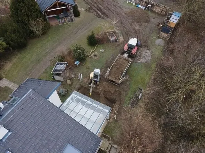 Framed Print : aerial drone shot of small, yellow excavator stands in a large garden and digs a hole for a pool in austria Framed Print : aerial drone shot of small, yellow excavator stands in a large garden and digs a hole for a pool in austria