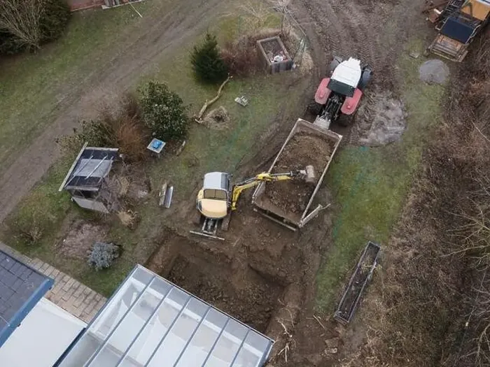 Framed Print : aerial drone shot of small, yellow excavator stands in a large garden and digs a hole for a pool in austria Framed Print : aerial drone shot of small, yellow excavator stands in a large garden and digs a hole for a pool in austria