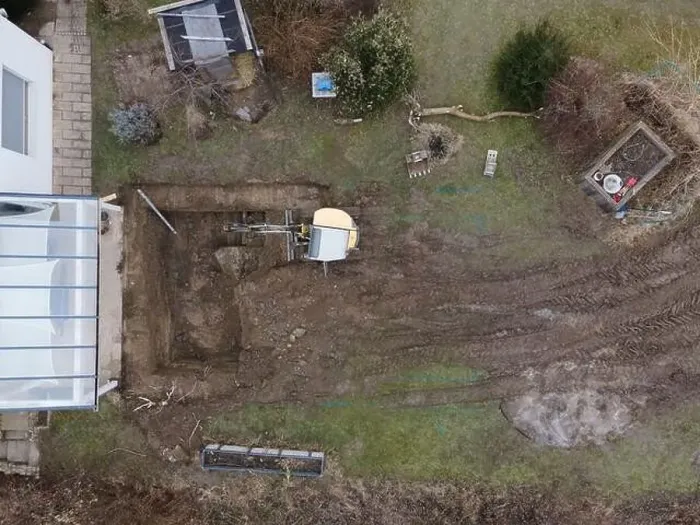 Framed Print : aerial drone shot of small, yellow excavator stands in a large garden and digs a hole for a pool in austria Framed Print : aerial drone shot of small, yellow excavator stands in a large garden and digs a hole for a pool in austria