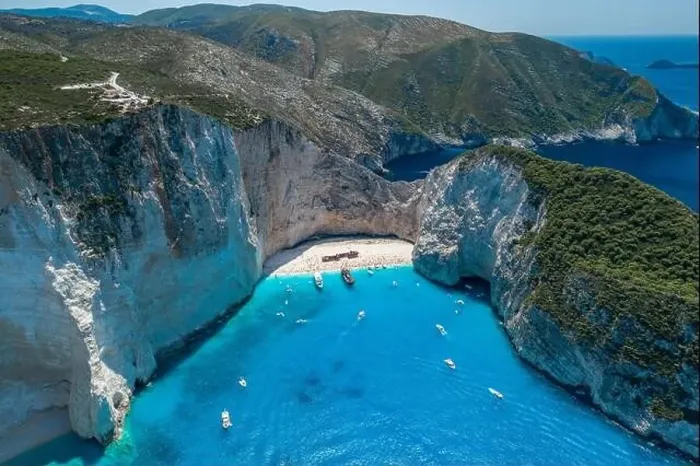 Framed Print : Aerial drone shot of Zakynthos Navagio beach with tourists with cruise ship in blue Ionnian sea Framed Print : Aerial drone shot of Zakynthos Navagio beach with tourists with cruise ship in blue Ionnian sea