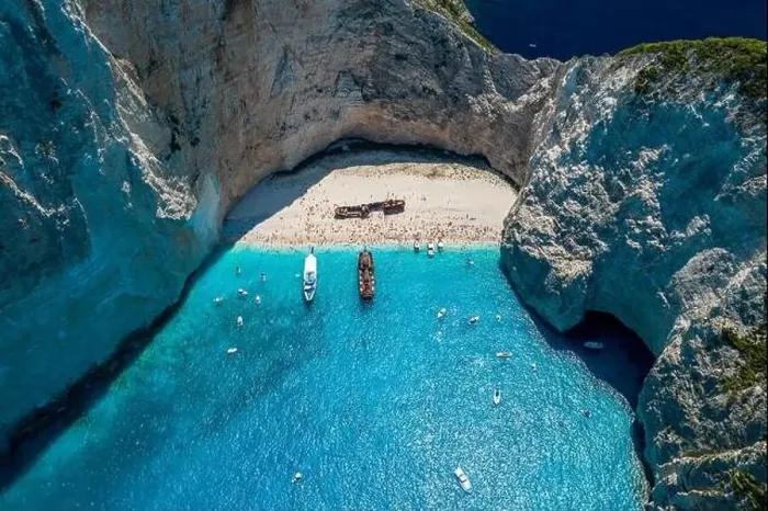 Framed Print : Aerial drone shot of Zakynthos Navagio beach with tourists with cruise ship in blue Ionnian sea Framed Print : Aerial drone shot of Zakynthos Navagio beach with tourists with cruise ship in blue Ionnian sea
