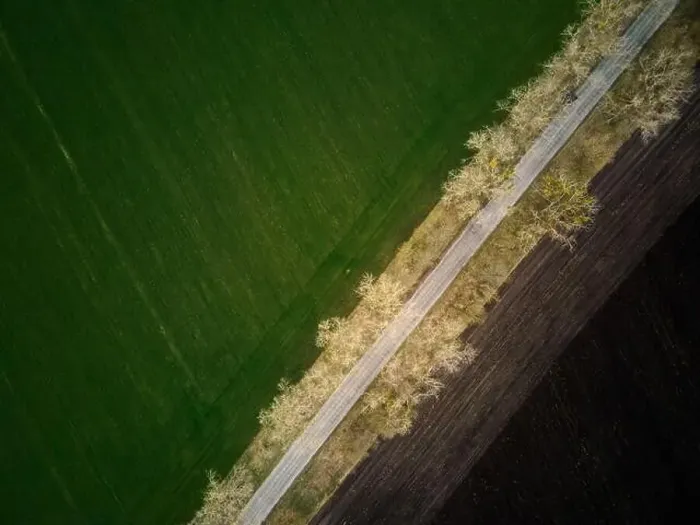 Framed Print : Aerial drone top view flight over ground land road and green field Framed Print : Aerial drone top view flight over ground land road and green field