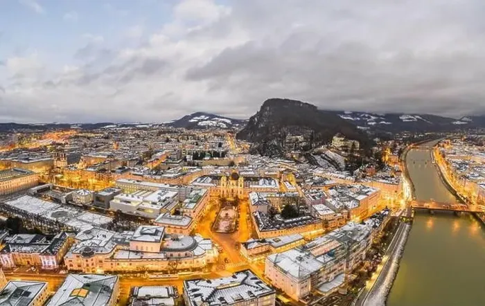 Framed Print : Aerial drone view of Holy Trinity Church in Salzburg covered with snow in winter at dusk with city lights on Framed Print : Aerial drone view of Holy Trinity Church in Salzburg covered with snow in winter at dusk with city lights on