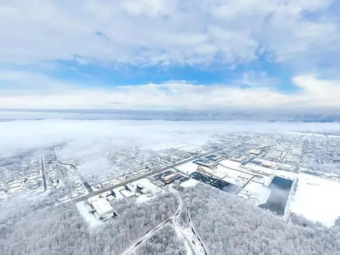 Framed Print : An aerial / drone view looking over a small city in Illinois after a snow storm with the clouds starting to clear Framed Print : An aerial / drone view looking over a small city in Illinois after a snow storm with the clouds starting to clear