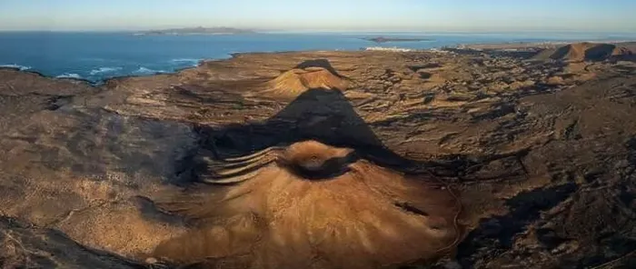 Framed Print : The aerial image captures a vast volcanic landscape bathed in the warm light of sunset Framed Print : The aerial image captures a vast volcanic landscape bathed in the warm light of sunset