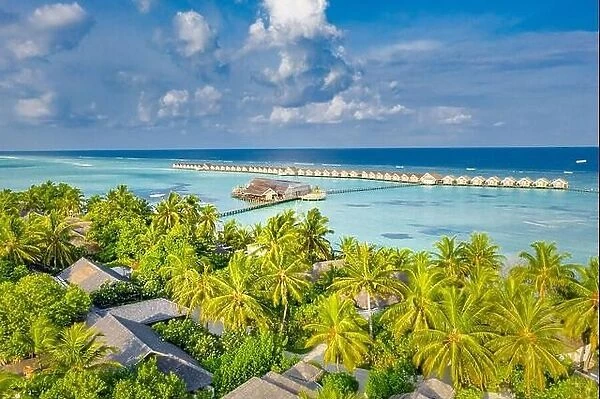 Aerial landscape, luxury tropical resort or hotel with water villas and beautiful beach scenery. Amazing bird eyes view in Maldives landscape seascape