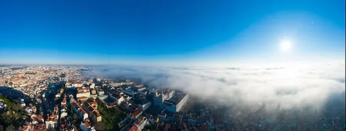 Framed Print : Aerial; panoramic drone view of foggy Lisbon morning; impending clouds over the ancient ginger roofs; blue skyline