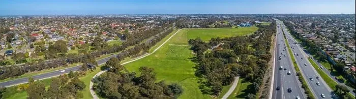 Framed Print : Aerial panoramic landscape of cars driving on highway passing through typical suburban landscape in Melbourne, Australia