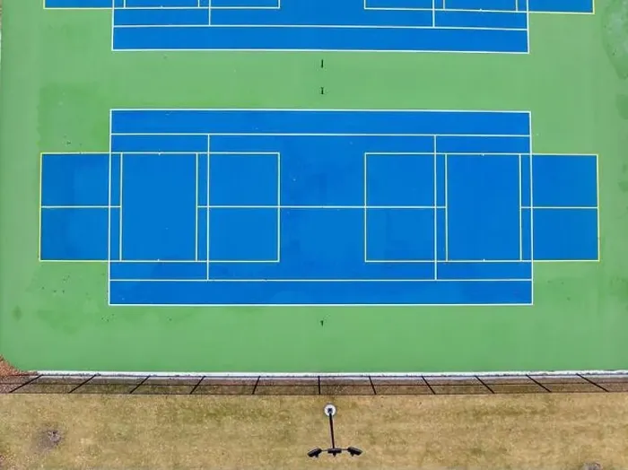 Framed Print : Aerial photo of unusually painted outdoor blue tennis courts with yellow pickleball lines and green out of bounds area Framed Print : Aerial photo of unusually painted outdoor blue tennis courts with yellow pickleball lines and green out of bounds area