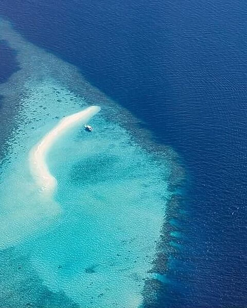 Aerial picture of turquoise blue tropical ocean lagoon, white sandy beach, sandbank coral reef shallow water with boat. Nature perfection in Maldives
