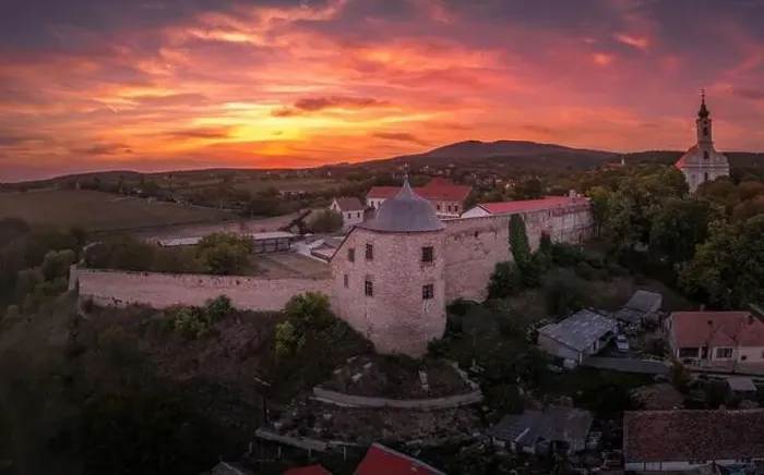 Framed Print : Aerial sunset shot of Pecsvarad fortified church and castle with tower, gate on a hilltop in Baranya county Hungary Framed Print : Aerial sunset shot of Pecsvarad fortified church and castle with tower, gate on a hilltop in Baranya county Hungary