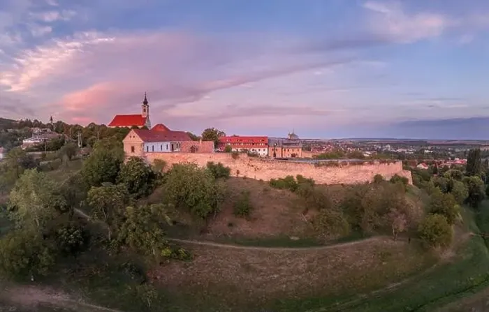 Framed Print : Aerial sunset shot of Pecsvarad fortified church and castle with tower, gate on a hilltop in Baranya county Hungary Framed Print : Aerial sunset shot of Pecsvarad fortified church and castle with tower, gate on a hilltop in Baranya county Hungary