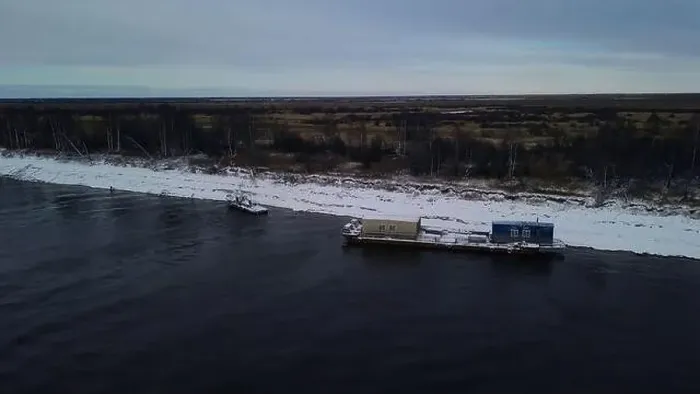 Framed Print : Aerial view of a barge on a winter river with ice. Clip. Concept of water transportation of goods