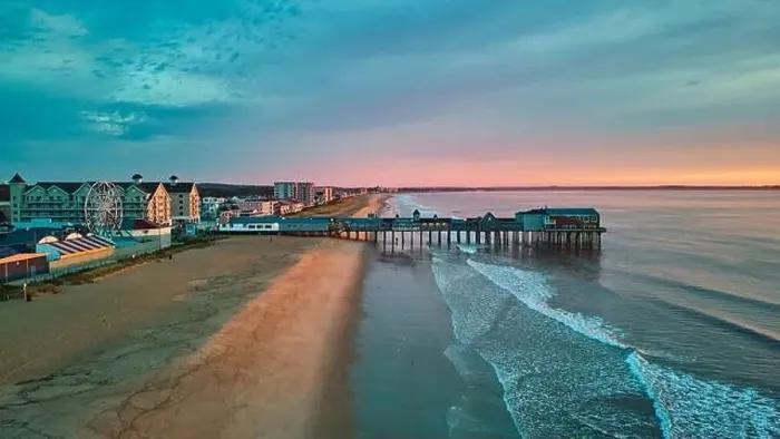 Framed Print : Aerial view over beach in Maine during sunrise with town and old wood pier of shops Framed Print : Aerial view over beach in Maine during sunrise with town and old wood pier of shops