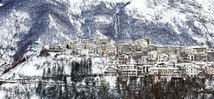 Framed Print : Aerial view of the beautiful snow-covered village of Opi with snow-capped mountains in the background