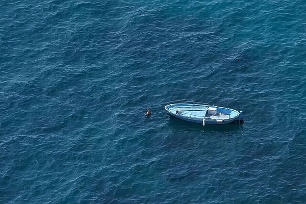 Aerial view of a blue boat on a blue clear sea water