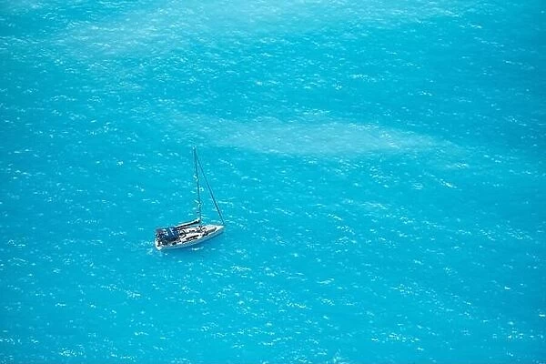 Aerial view over a boat on turquoise sea water, in sunny summer day in Ioniam Sea, Greece