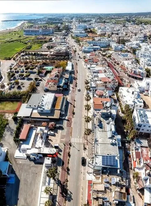 Framed Print : Aerial view of a city center of Ayia Napa with an empty street running through it towards the sea on a sunny day. Cyprus