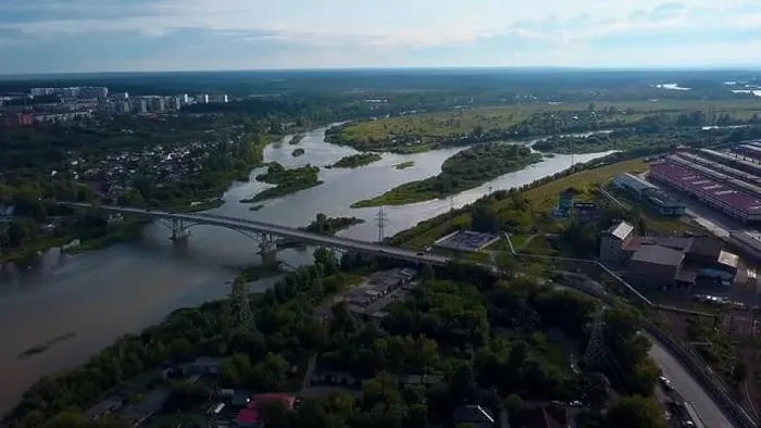 Framed Print : Aerial view of the city parts connected by the bridge. Clip. Wide river flowing along green vegetation and buildings Framed Print : Aerial view of the city parts connected by the bridge. Clip. Wide river flowing along green vegetation and buildings