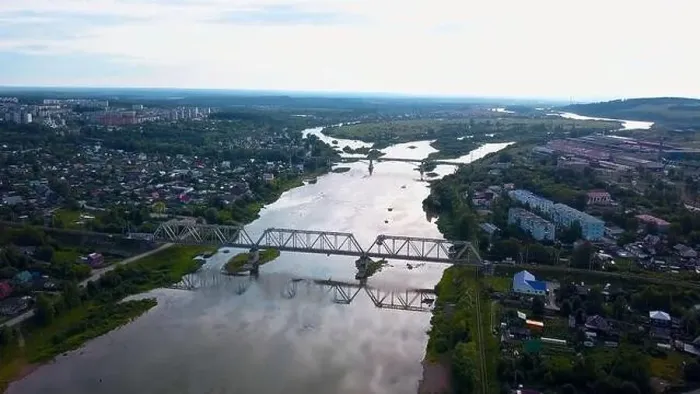 Framed Print : Aerial view of the city and a wide river with a bridge. Clip. Flying above summer city on a bright sky background Framed Print : Aerial view of the city and a wide river with a bridge. Clip. Flying above summer city on a bright sky background