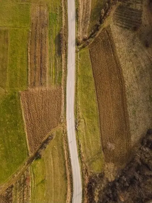 Framed Print : Aerial view top down from above on the country road in mountain range in between fields grass Framed Print : Aerial view top down from above on the country road in mountain range in between fields grass