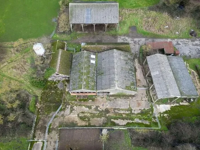 Framed Print : Aerial view of derelict farm buildings including hay barns and cow milking parlours. A grain silo is on the left Framed Print : Aerial view of derelict farm buildings including hay barns and cow milking parlours. A grain silo is on the left