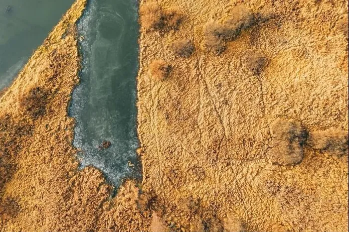Framed Print : Aerial View Of Dry Grass And Partly Frozen River Landscape In Late Autumn Day. High Attitude View. Marsh Bog. Drone View. Bird's Eye View Framed Print : Aerial View Of Dry Grass And Partly Frozen River Landscape In Late Autumn Day. High Attitude View. Marsh Bog. Drone View. Bird's Eye View