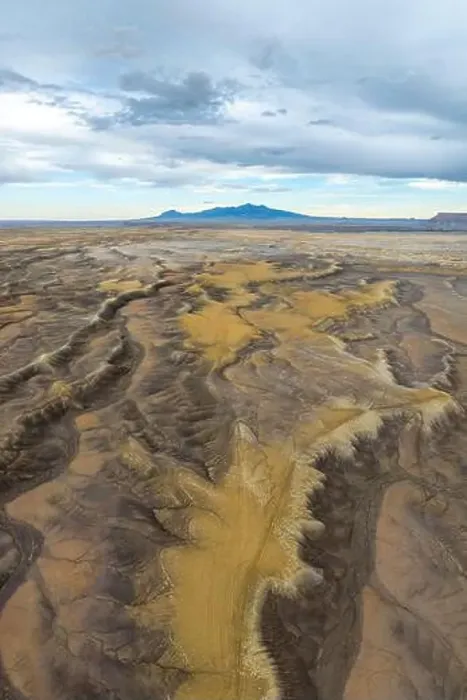Framed Print : Aerial view of an expansive desert terrain featuring rugged formations and soft sand hues in Hanskville Framed Print : Aerial view of an expansive desert terrain featuring rugged formations and soft sand hues in Hanskville