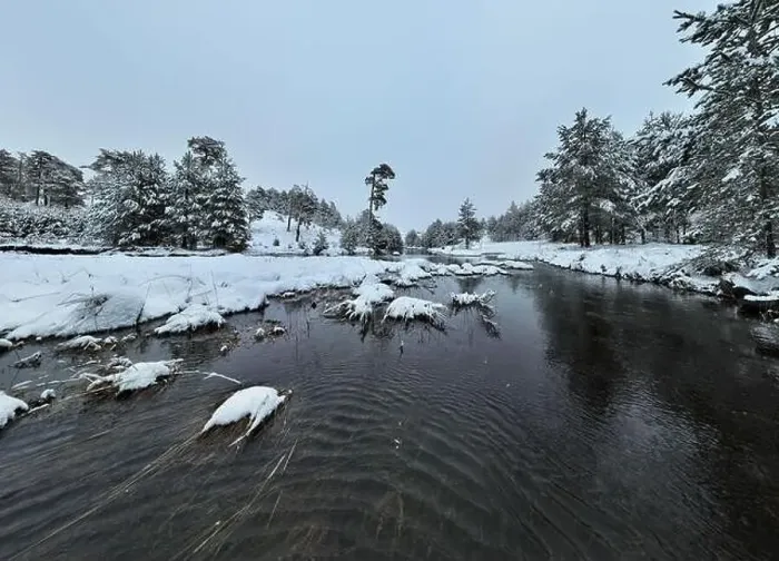 Framed Print : An aerial view of a frozen river flowing through snow-covered forests on a cloudy sunset sky background Framed Print : An aerial view of a frozen river flowing through snow-covered forests on a cloudy sunset sky background