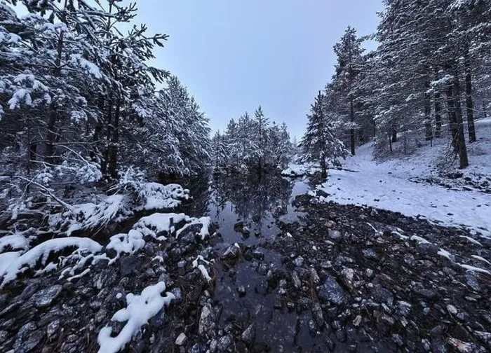 Framed Print : An aerial view of a frozen river flowing through snow-covered forests on a cloudy sunset sky background Framed Print : An aerial view of a frozen river flowing through snow-covered forests on a cloudy sunset sky background