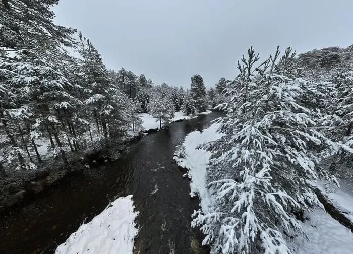 Framed Print : An aerial view of a frozen river flowing through snow-covered forests on a cloudy sunset sky background Framed Print : An aerial view of a frozen river flowing through snow-covered forests on a cloudy sunset sky background