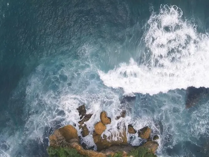Framed Print : Top down aerial view of giant ocean waves crashing and foaming in coral beach
