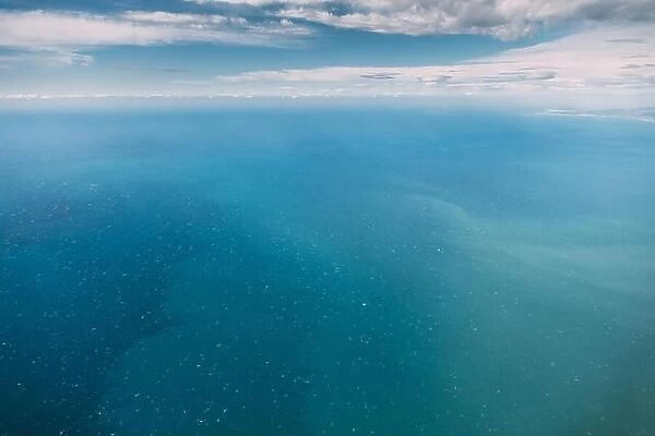 Aerial View From High Altitude Flight Of Aircraft On Sea Ocean Surface. Natural Sea Background