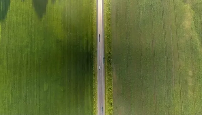 Framed Print : Aerial top view of a landscape while traveling by car on an asphalt highway in the middle of a green agricultural field Framed Print : Aerial top view of a landscape while traveling by car on an asphalt highway in the middle of a green agricultural field