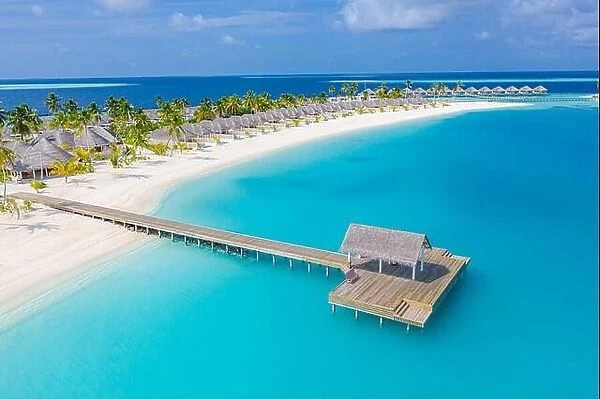 Aerial view of Maldives island, luxury water villas resort and wooden pier. Beautiful sky and ocean lagoon beach background. Summer vacation holiday