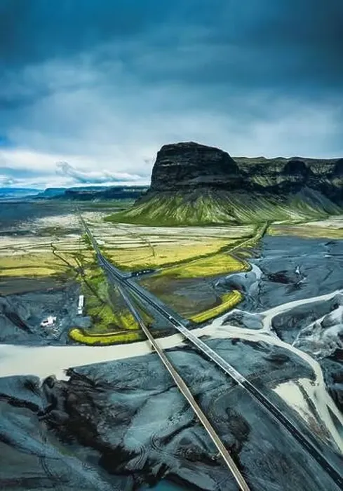 Framed Print : Aerial view of moody rugged volcanic Lomagnupur mountain and highway over glacier river Framed Print : Aerial view of moody rugged volcanic Lomagnupur mountain and highway over glacier river