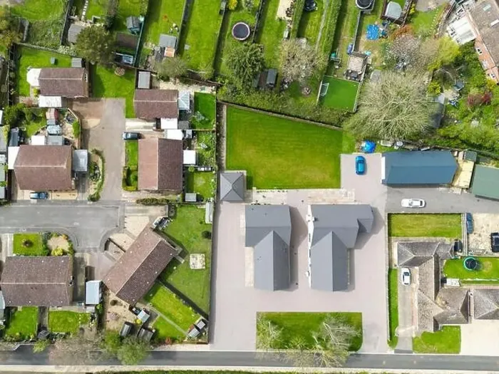 Framed Print : Aerial top down view of a pair of new detached bungalows seen adjacent to established housing and gardens Framed Print : Aerial top down view of a pair of new detached bungalows seen adjacent to established housing and gardens