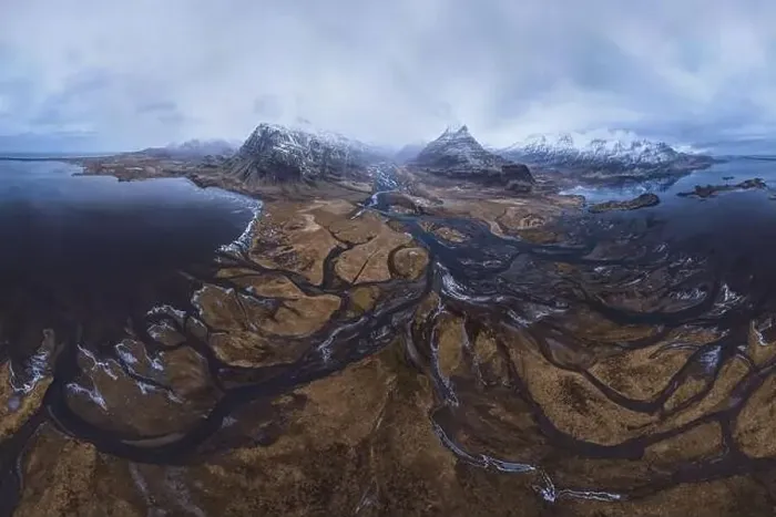 Framed Print : From above aerial view of river estuary and ocean coast near mountain peaks covered with snow in winter time in Iceland Framed Print : From above aerial view of river estuary and ocean coast near mountain peaks covered with snow in winter time in Iceland
