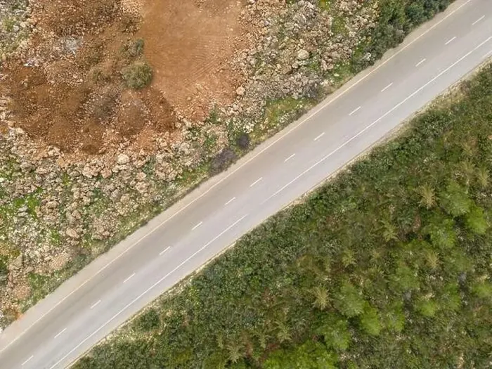 Framed Print : Aerial view of the road with trees on one side and dirt on the other Framed Print : Aerial view of the road with trees on one side and dirt on the other